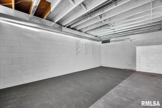 unfinished basement featuring concrete block wall