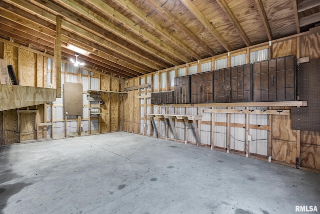 misc room with unfinished concrete floors and lofted ceiling