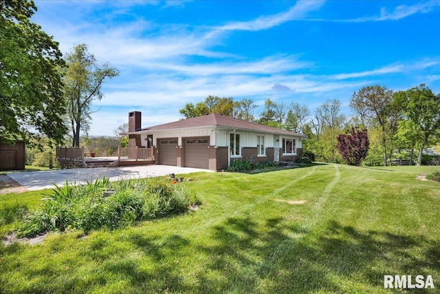 view of front of house featuring a garage, a chimney, brick siding, a front yard, and concrete driveway