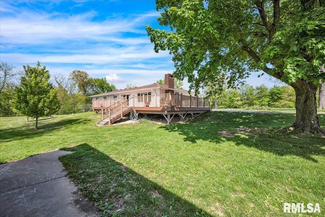 rear view of house with a wooden deck, a yard, a chimney, and stairway