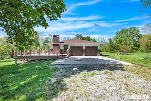 ranch-style home featuring a chimney, brick siding, a front yard, an attached garage, and a deck