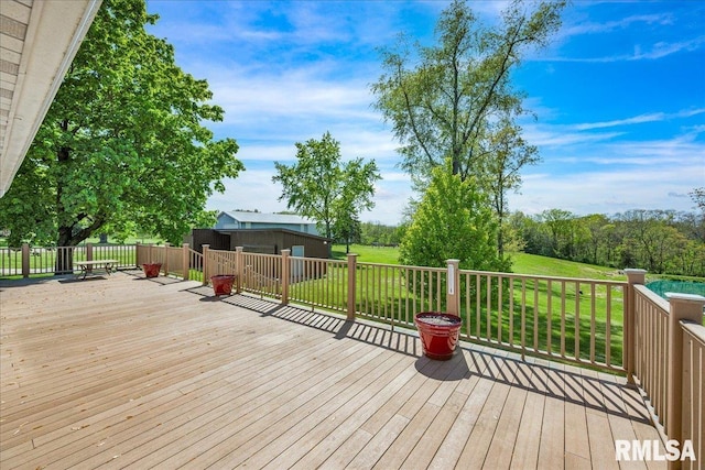 wooden deck featuring a yard and an outbuilding
