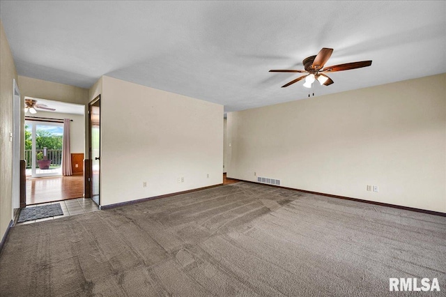 carpeted empty room with a ceiling fan and baseboards