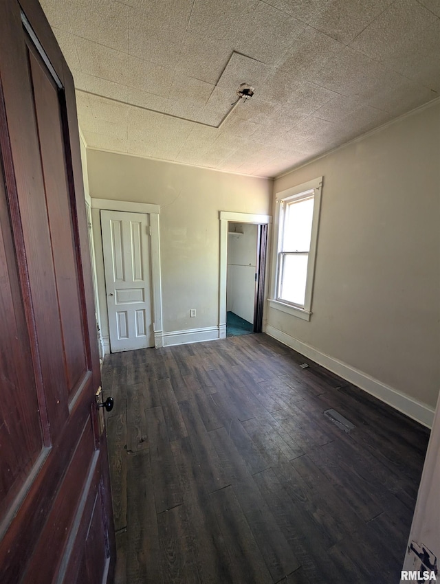 2217 NE Madison Ave, Peoria, IL 61603 - unfurnished bedroom with dark wood-style floors, baseboards, and a closet