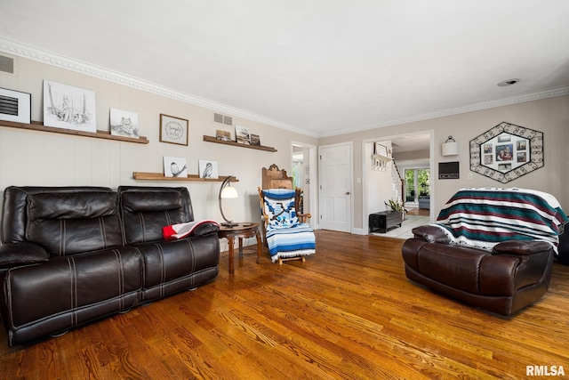 living room with wood finished floors and crown molding
