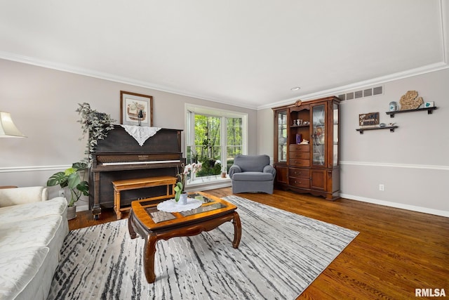 living area with ornamental molding, baseboards, and wood finished floors