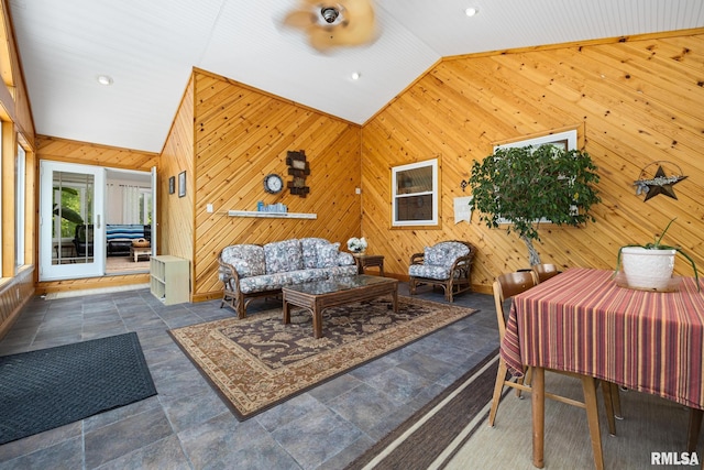living room with lofted ceiling, wood walls, stone finish floors, and recessed lighting