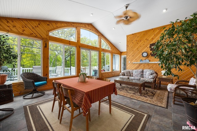 sunroom with lofted ceiling and wood walls