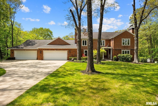 view of front of home with a chimney, an attached garage, driveway, and a front yard