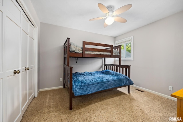 carpeted bedroom featuring baseboards, a ceiling fan, and a closet