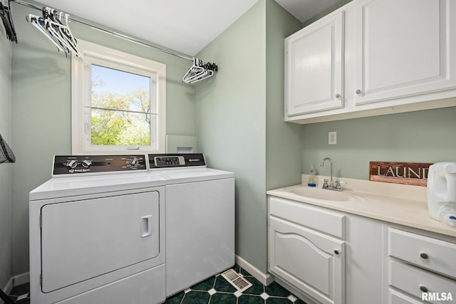washroom featuring cabinet space, washing machine and clothes dryer, and baseboards