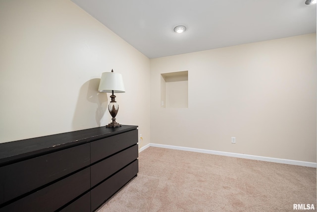 bedroom featuring light carpet and baseboards