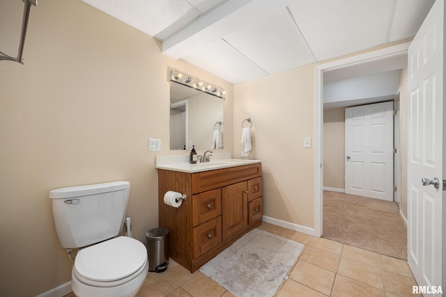 bathroom featuring tile patterned flooring, toilet, vanity, and baseboards