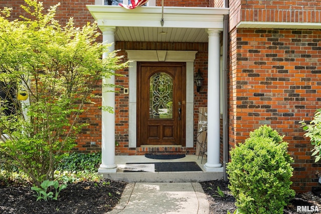 entrance to property featuring brick siding