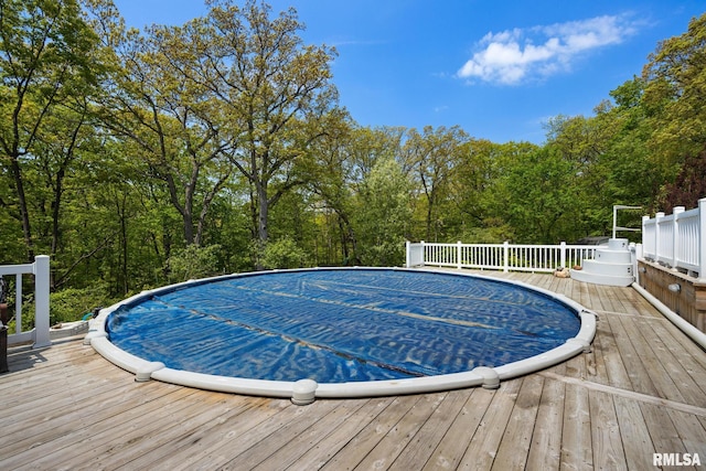 view of swimming pool featuring a deck and a covered pool