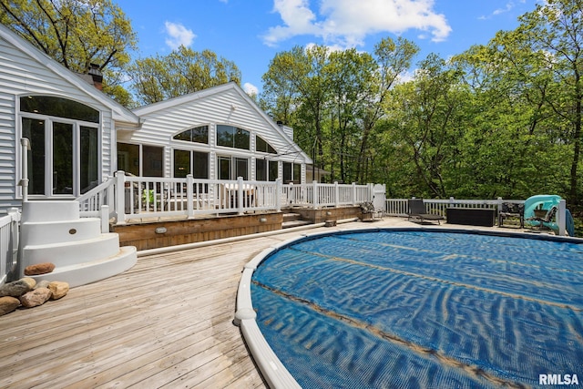 view of swimming pool with a deck and a covered pool