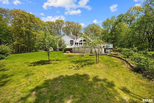 view of green lawn featuring a wooden deck