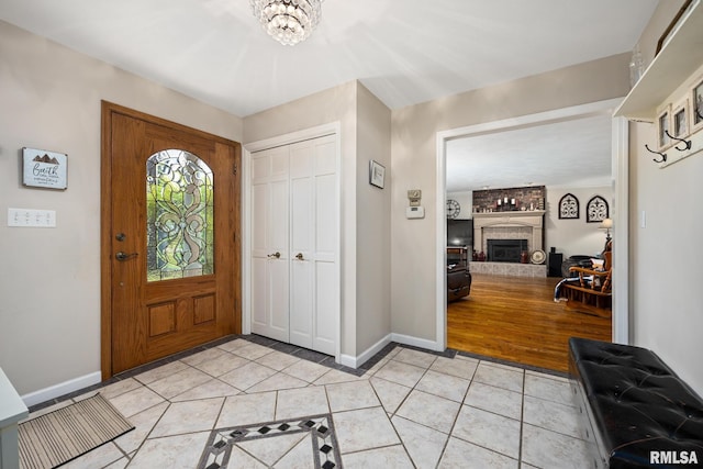 entryway with light tile patterned flooring, baseboards, and a chandelier