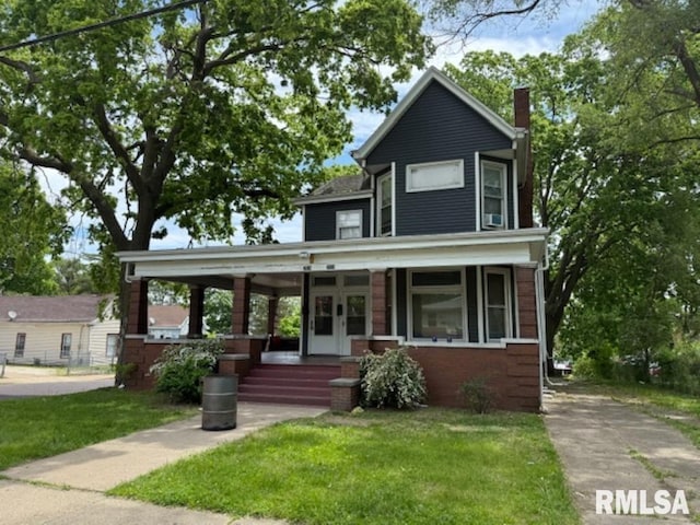 2826 NE Madison Ave, Peoria, IL 61603 - view of front facade featuring a porch, a front yard, a chimney, and brick siding