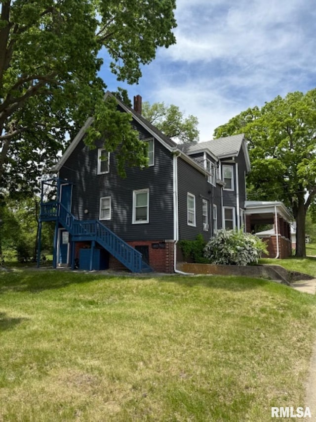 2826 NE Madison Ave, Peoria, IL 61603 - view of front of home featuring stairway, a chimney, and a front yard