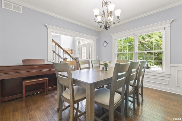 dining area featuring a chandelier, dark wood-style floors, a wainscoted wall, and crown molding