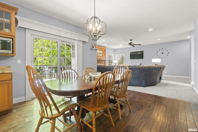 dining area with baseboards, hardwood / wood-style floors, recessed lighting, ceiling fan, and a chandelier