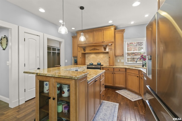 kitchen featuring appliances with stainless steel finishes, a sink, dark wood-type flooring, backsplash, and recessed lighting