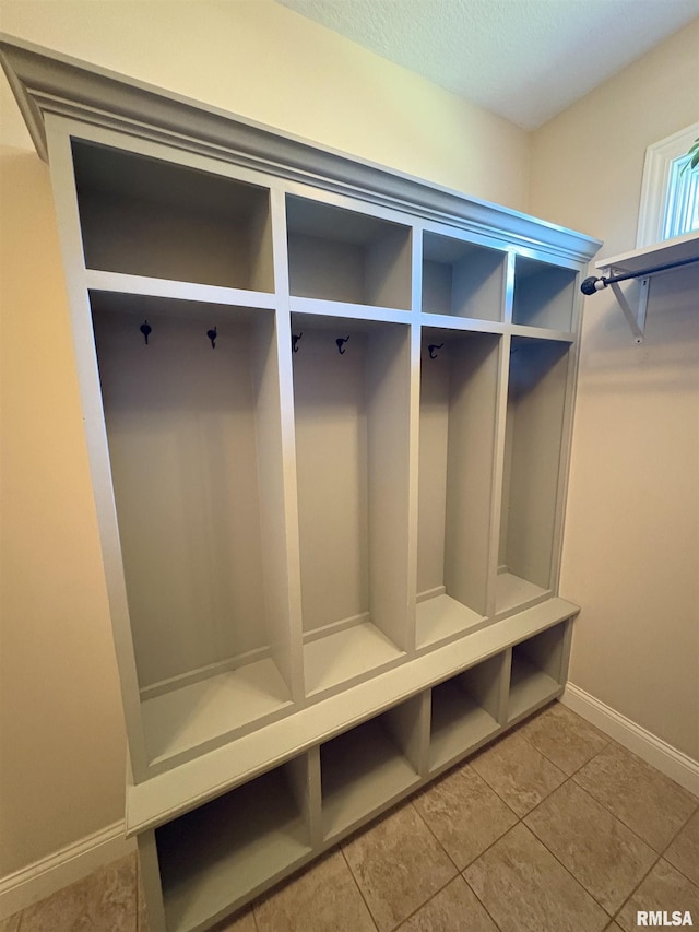 mudroom with baseboards and tile patterned flooring