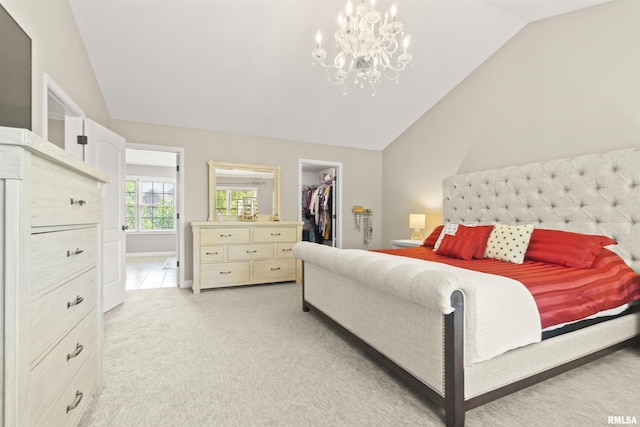 bedroom with vaulted ceiling, a spacious closet, light carpet, a chandelier, and a closet