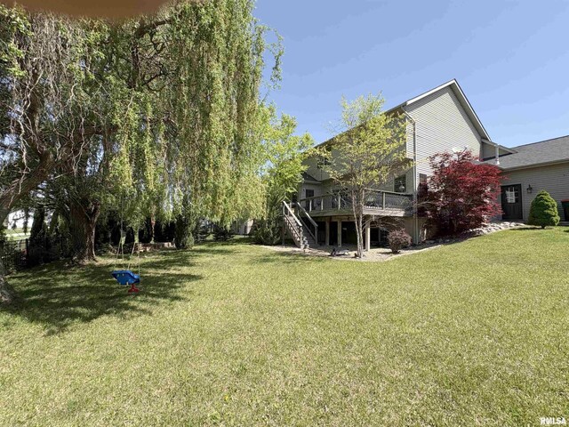 view of grassy yard with stairway and a deck