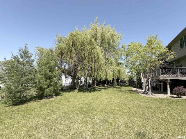 view of green lawn with a deck