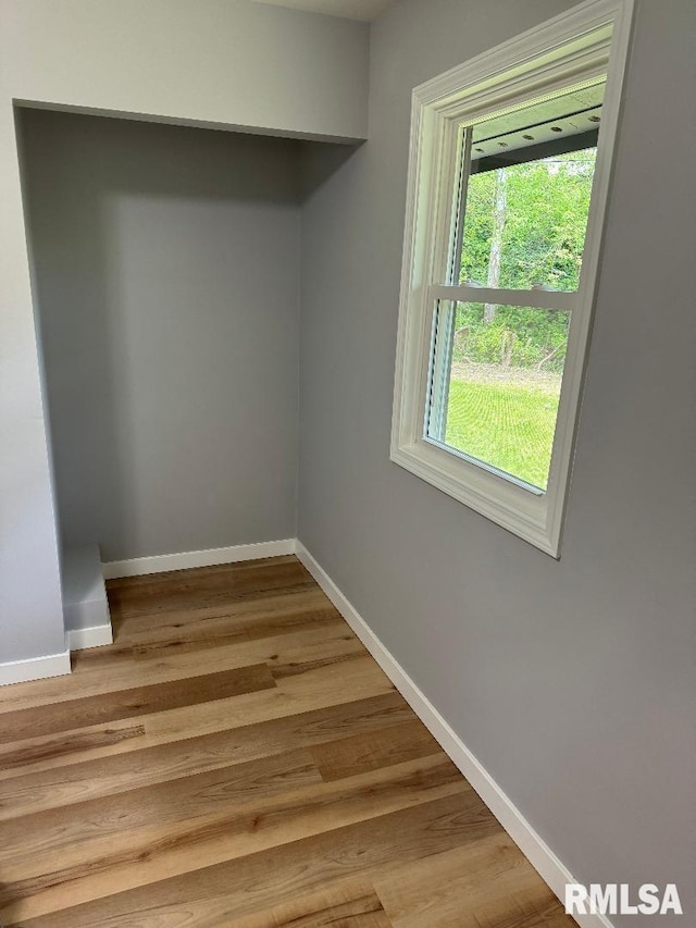 spare room featuring baseboards and light wood-style flooring