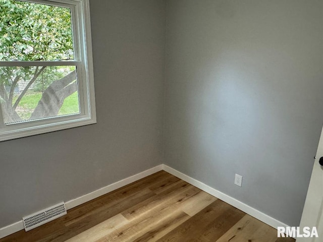 spare room featuring baseboards and dark wood-style flooring