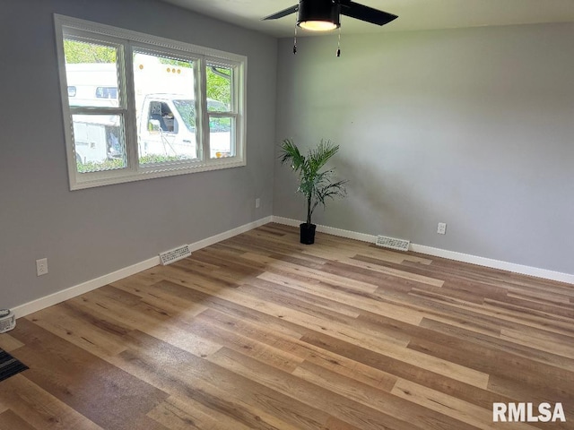 spare room with ceiling fan, wood finished floors, and baseboards