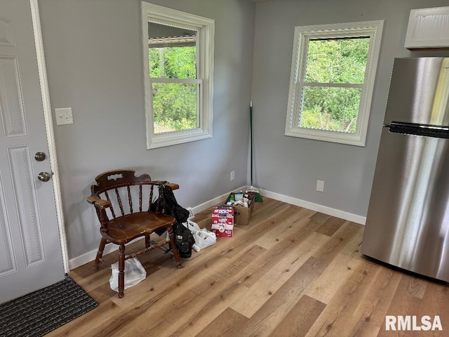 living area with baseboards and light wood-style flooring