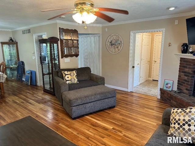 1635 W Country Oaks Ct, Dunlap, IL 61525 - living area with wood finished floors, ceiling fan, crown molding, a fireplace, and a textured ceiling