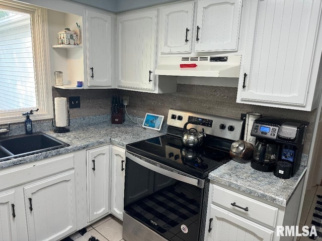 1635 W Country Oaks Ct, Dunlap, IL 61525 - kitchen featuring stainless steel electric range, under cabinet range hood, open shelves, light tile patterned floors, and white cabinetry
