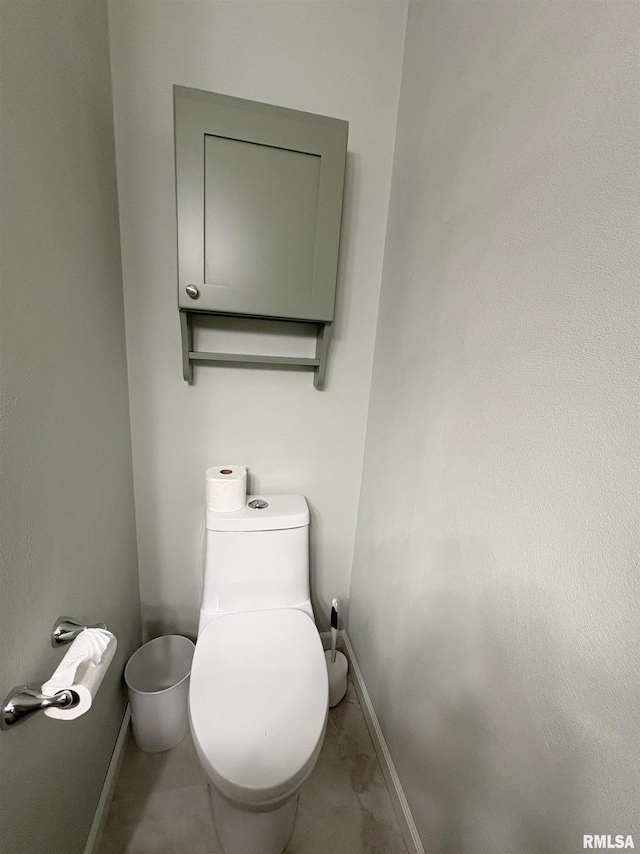 bathroom with baseboards and toilet