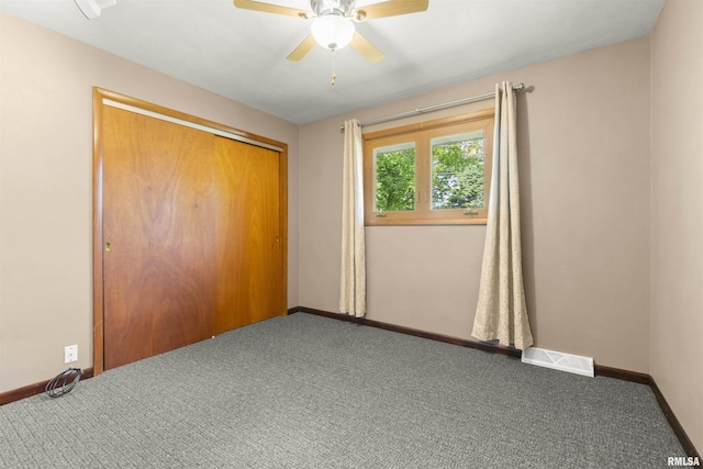 unfurnished bedroom featuring baseboards, carpet floors, a closet, and a ceiling fan