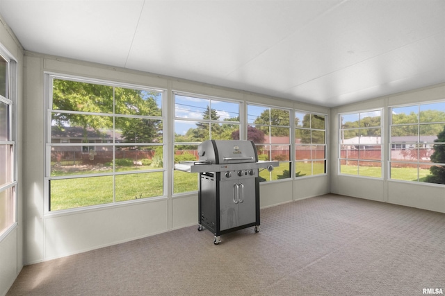 unfurnished sunroom with healthy amount of natural light and carpet