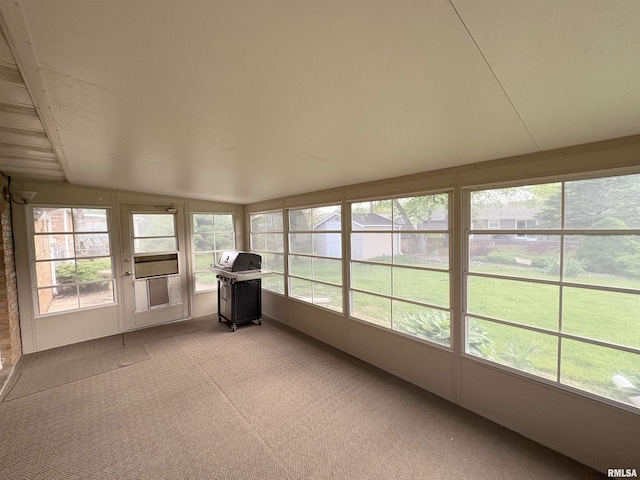 unfurnished sunroom featuring carpet floors and lofted ceiling