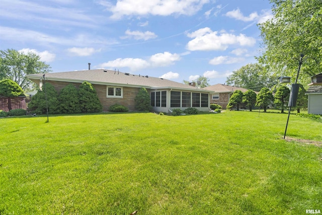 rear view of house with a yard and brick siding