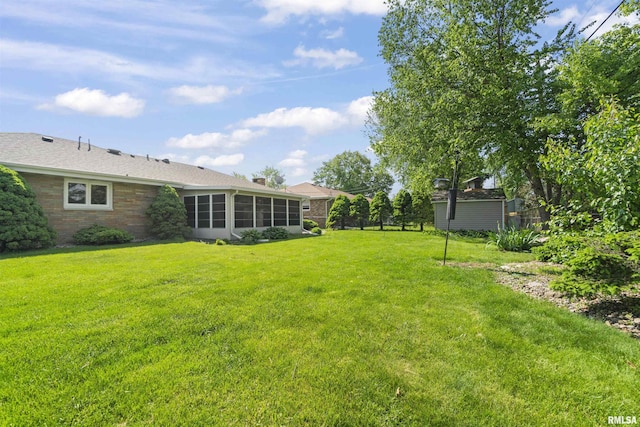 view of green lawn with a sunroom