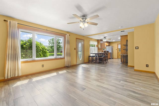 living room with ceiling fan, light wood-style floors, and baseboards