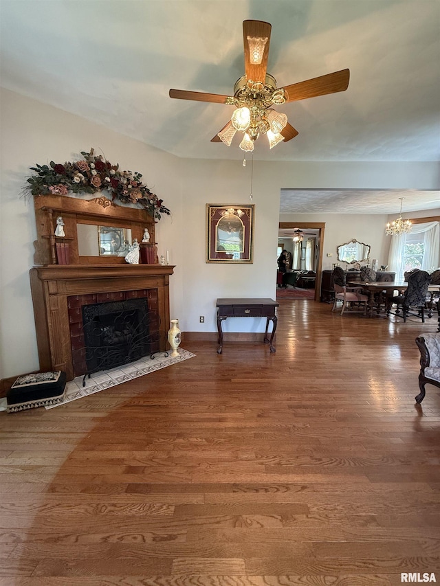 111 N Broadway St, Lewistown, IL 61542 - living area featuring ceiling fan, wood finished floors, a chandelier, and a fireplace