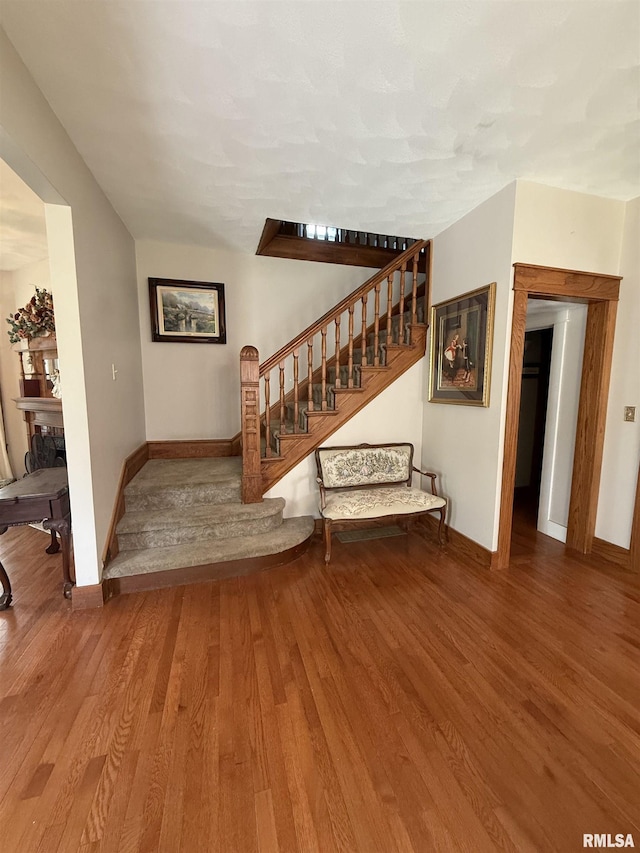 111 N Broadway St, Lewistown, IL 61542 - unfurnished living room featuring baseboards, stairs, and wood finished floors