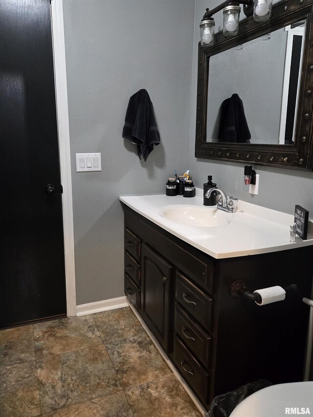 212 Conch Dr, La Harpe, IL 61450 - bathroom with vanity, baseboards, and stone finish floors