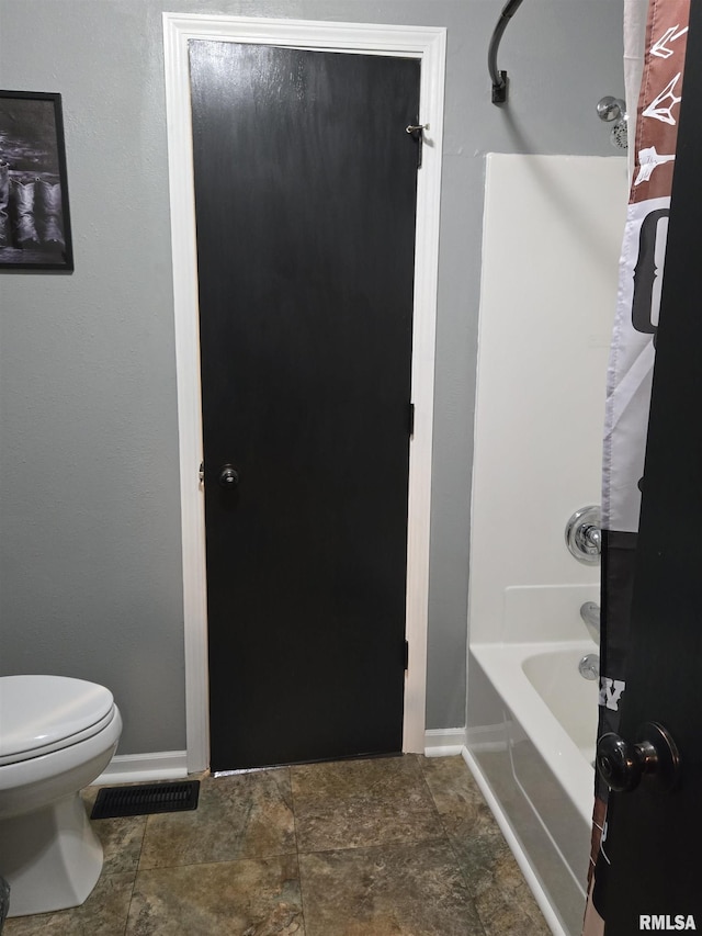 212 Conch Dr, La Harpe, IL 61450 - bathroom with toilet, baseboards, and shower / bath combination