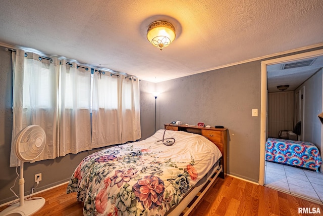 1425 N Vaughn Ave, West Peoria, IL 61604 - bedroom featuring a textured ceiling, wood finished floors, and baseboards