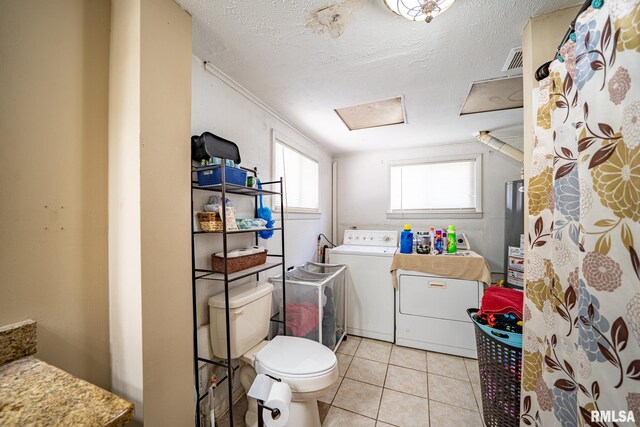 1425 N Vaughn Ave, West Peoria, IL 61604 - bathroom featuring independent washer and dryer, toilet, tile patterned floors, gas water heater, and a textured ceiling
